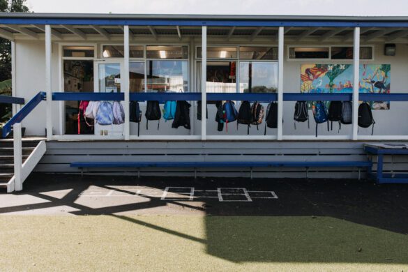 Primary school building verandah with school bags hanging on hooks.